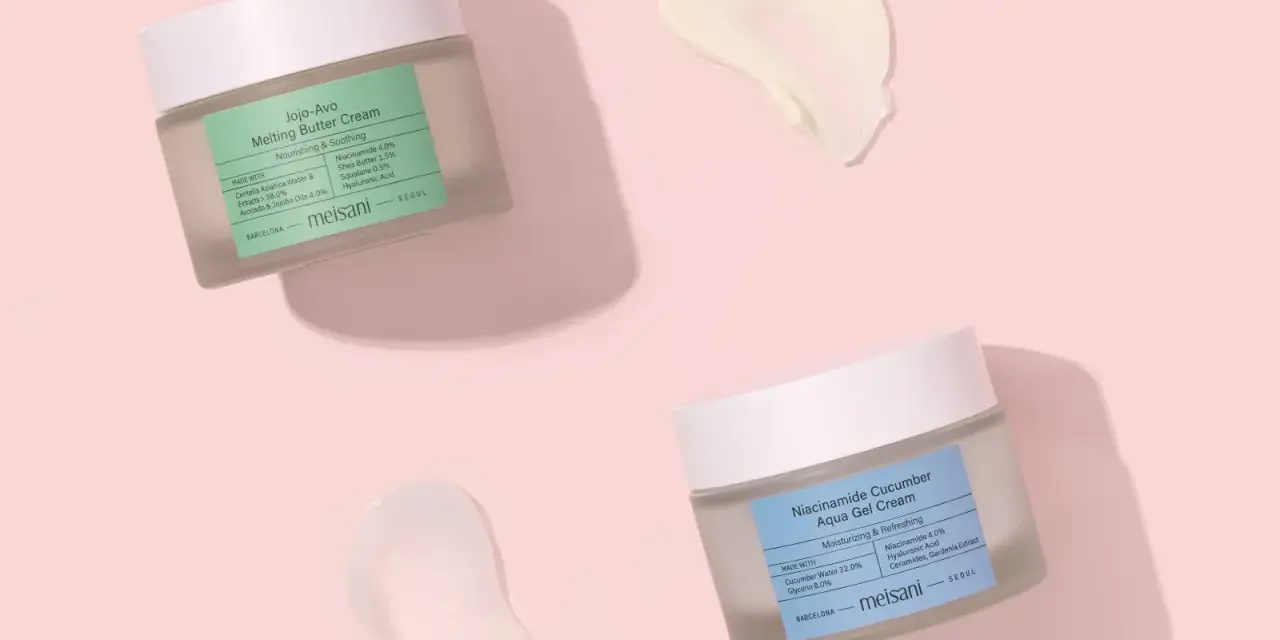 Due barattoli di crema viso Meisani, uno con niacinamide e burro, l'altro con niacinamide e cetriolo, su sfondo rosa. Perfetti per proteggere la pelle dal sole.