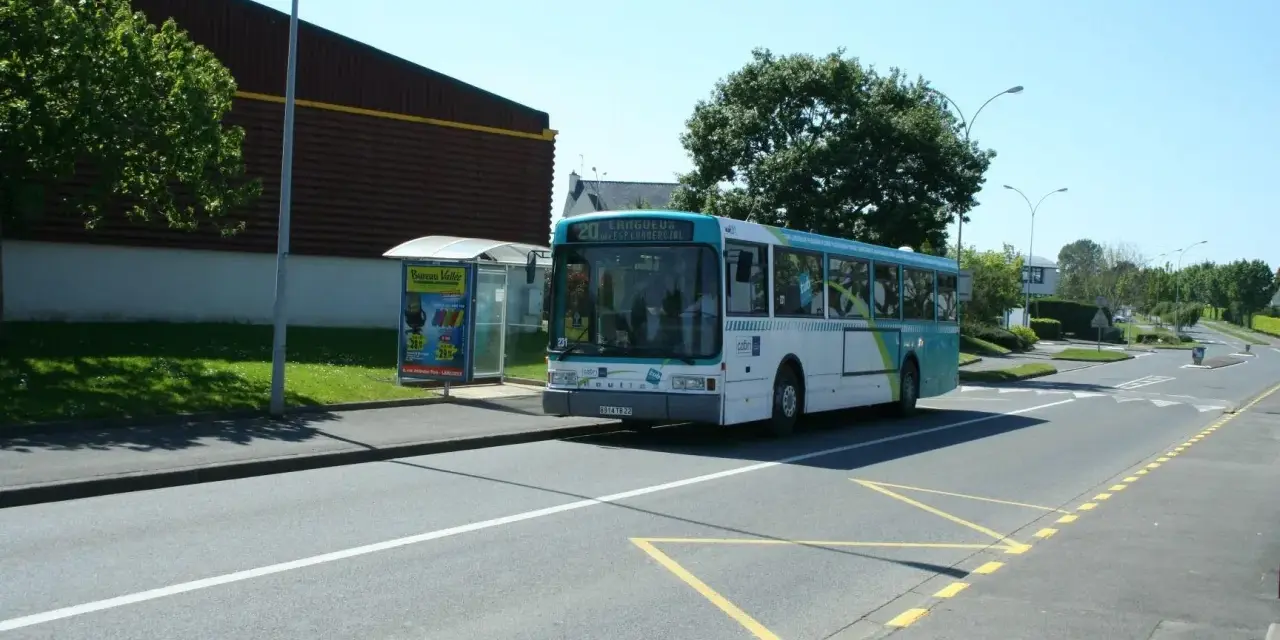 Un bus scolaire s'arrête à un arrêt de bus, respectant le code de la route. Le soleil brille sur la route.