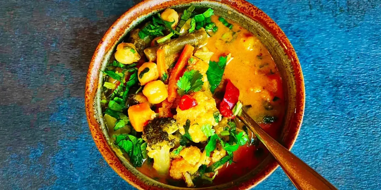 Miseczka tajskiego curry z warzywami, ciecierzycą i mlekiem kokosowym.