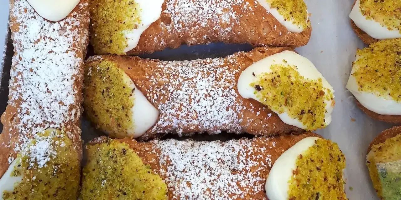 Chrupiące rurki z kremem i pistacjami, posypane cukrem pudrem. Idealny przepis na cannoli!