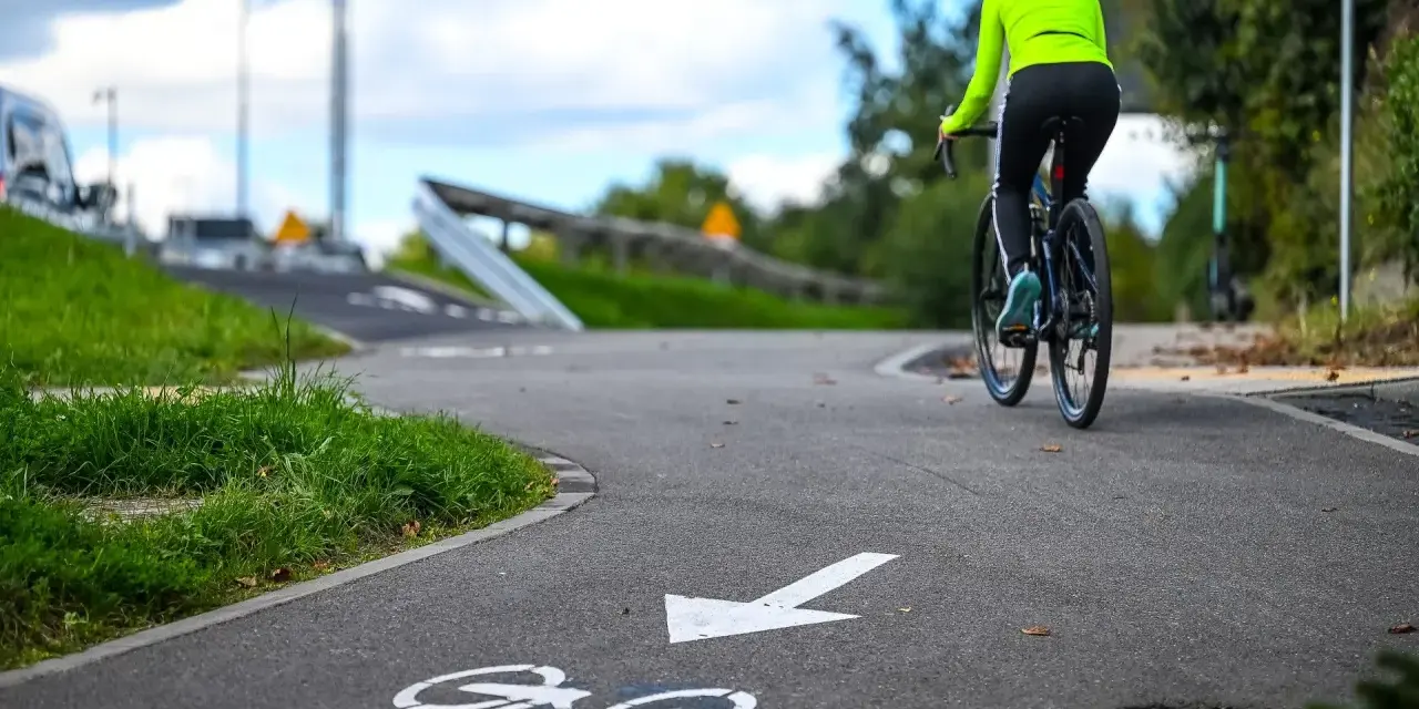 Kobieta na rowerze przemierza malownicze trasy rowerowe Kujawsko-Pomorskie.