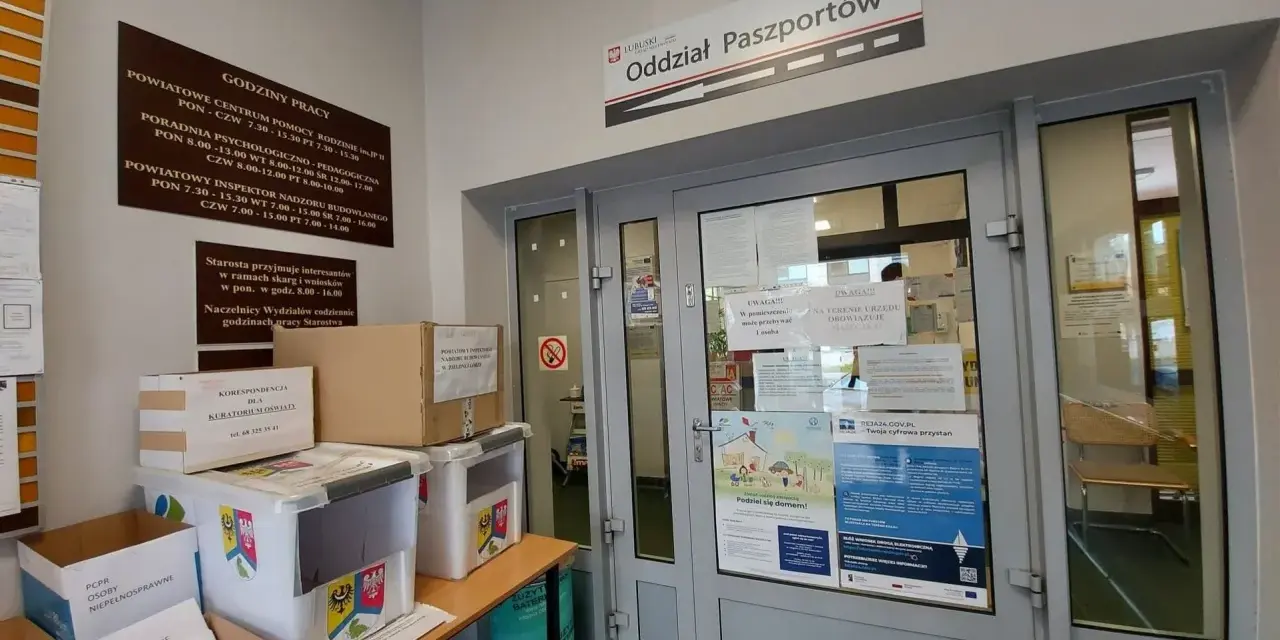 Oddział Paszportów w Zielonej Górze. W holu stoją pudła i pojemniki, a na drzwiach wiszą ogłoszenia.