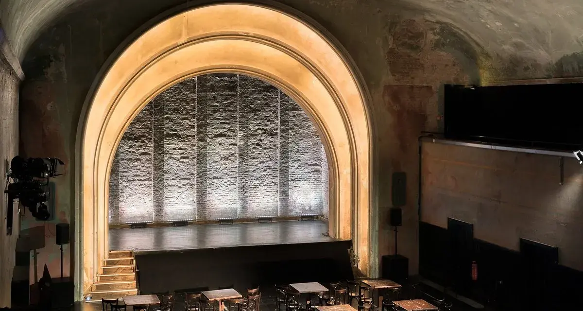 Das **Theater im Delphi** mit seiner beeindruckenden Bogenarchitektur und der beleuchteten Bühne lädt zu unvergesslichen Vorstellungen ein.