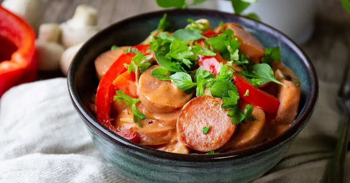 En mustig korvgryta med chorizo, paprika och örter i en krämig sås. Serveras i en rustik skål.