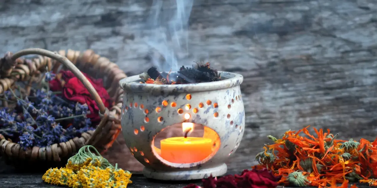Aromas de lavanda, rosas y caléndula se elevan con el humo de un quemador de incienso, creando un ambiente de limpieza de energías.