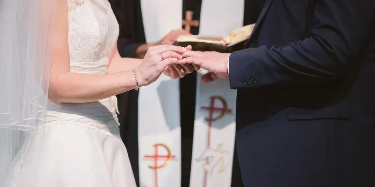 Para młoda wymienia obrączki podczas ceremonii ślubnej w kościele.