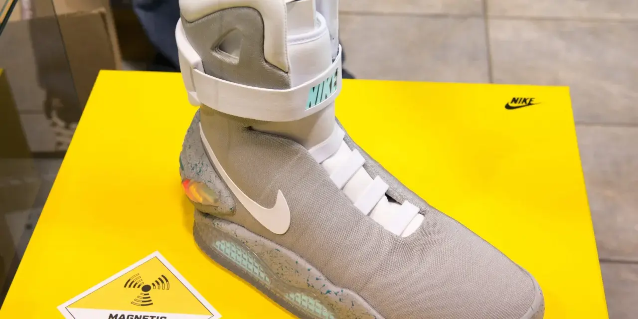 Nike Mag, najdroższe buty na świecie, z technologią "Magnetic Anti Gravity", prezentowane na żółtym tle.