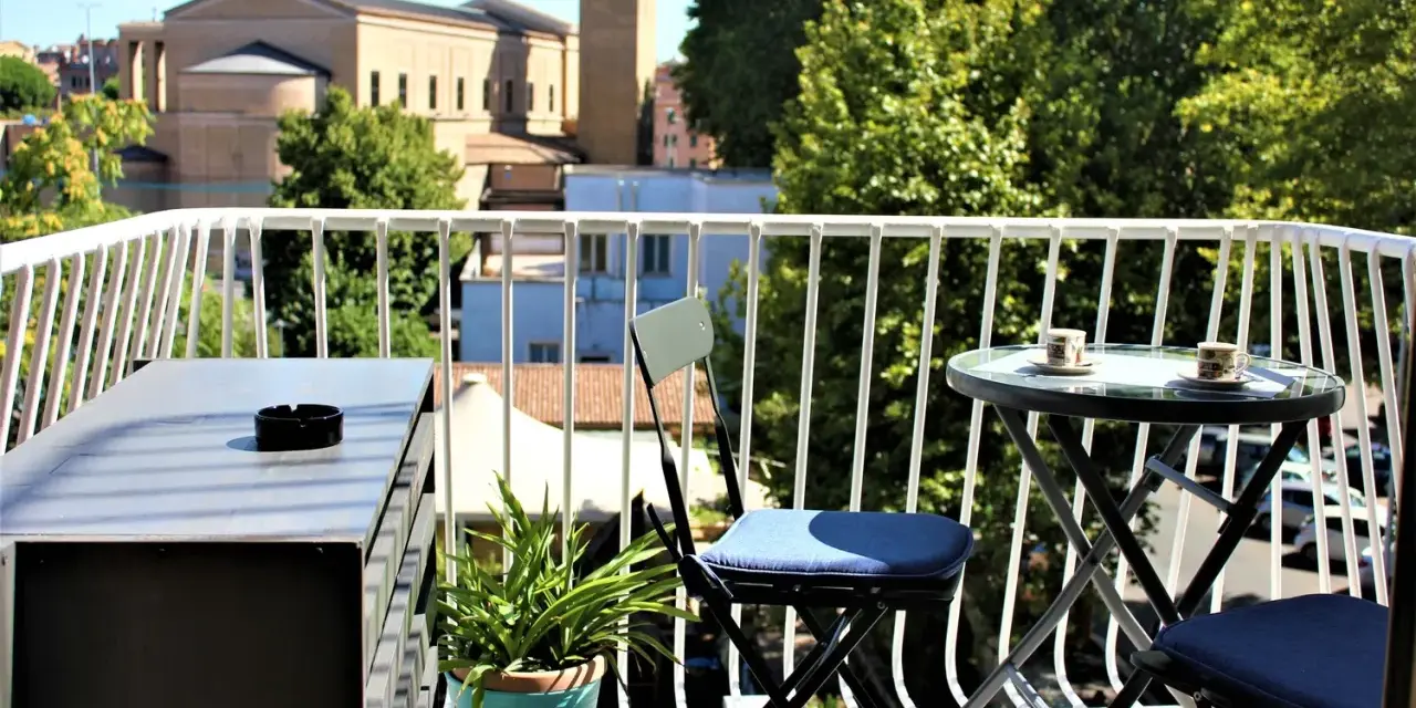 Balkon z widokiem na rzymskie dachy i kościół. Idealne miejsce, by zastanowić się, gdzie nocować w Rzymie.