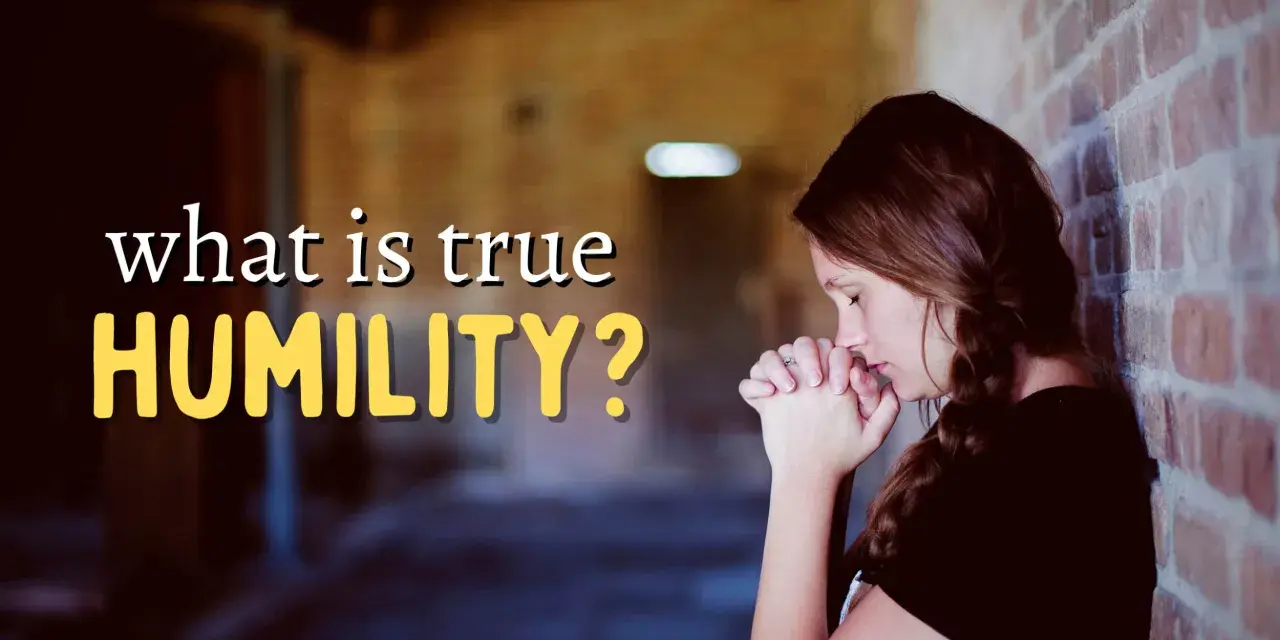 A woman with her hands clasped in prayer leans against a brick wall, contemplating "what is true HUMILITY?".