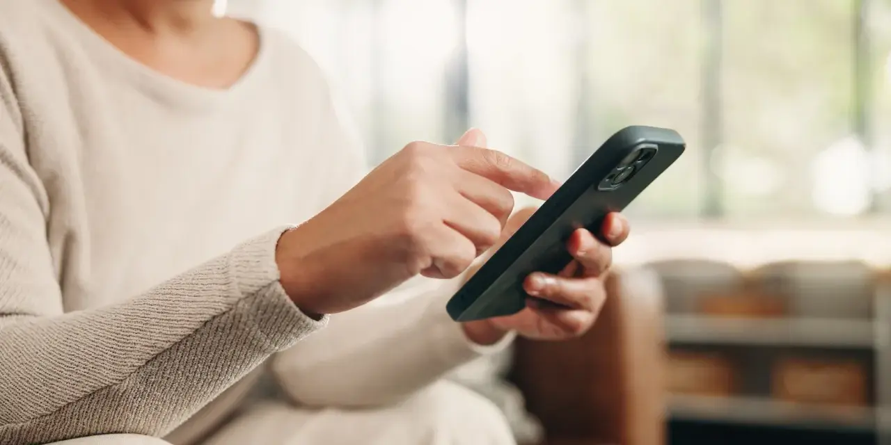 Dłoń z telefonem, przygotowująca się do wykonania czynności, jak przenieść dane z telefonu na telefon.