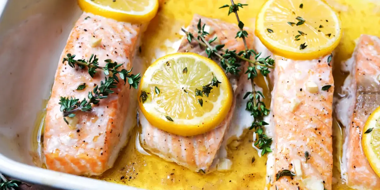Saftiger Lachs im Ofen, garniert mit Zitronenscheiben und frischem Thymian, bereit zum Genießen.
