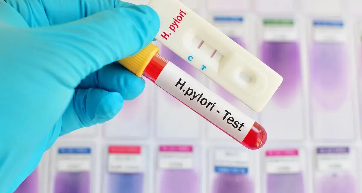 Rękawiczka trzyma probówkę z krwią i test H. pylori. Czasem objawy psychiczne mogą być związane z tą infekcją.