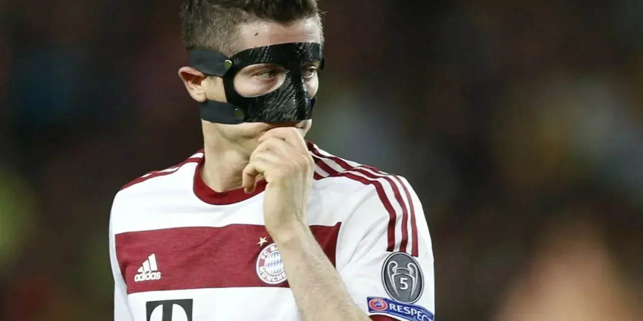 Piłkarz w masce ochronnej na twarzy, być może zastanawia się, dlaczego Lewandowski gra w masce.