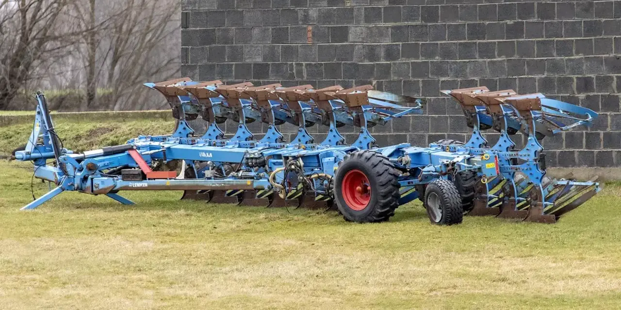 Potężny, niebieski pług 10 skibowy Lemken, gotowy do pracy na polu.