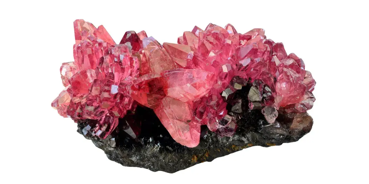 Cristalli di rodocrosite rosa brillante su matrice scura. Le sue proprietà sono note per stimolare amore e compassione.