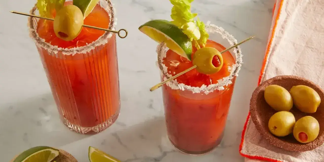 Dwa Bloody Mary: jedno na soku pomidorowym, drugie na passacie. Oba ozdobione łodygą selera, limonką i oliwką.