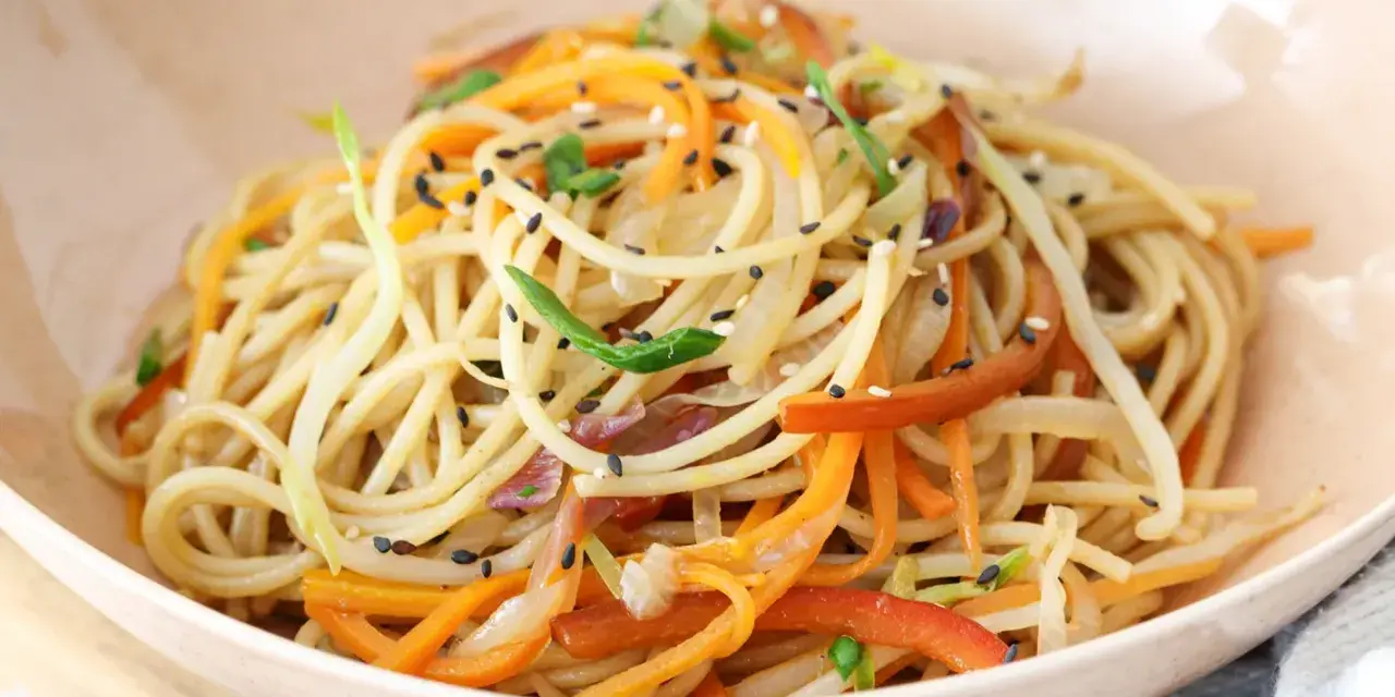 Chow mein en un tazón con verduras y semillas de sésamo.