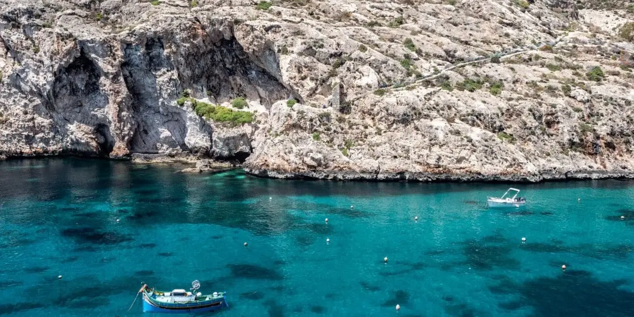 Malta, grudzień: turkusowa woda, skaliste klify i łodzie. Pogoda idealna na rejs.