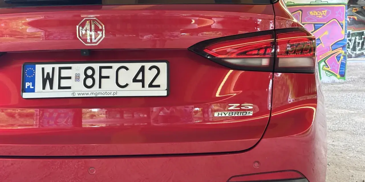 Czerwony tył samochodu MG ZS Hybrid z tablicą rejestracyjną WE 8FC42.