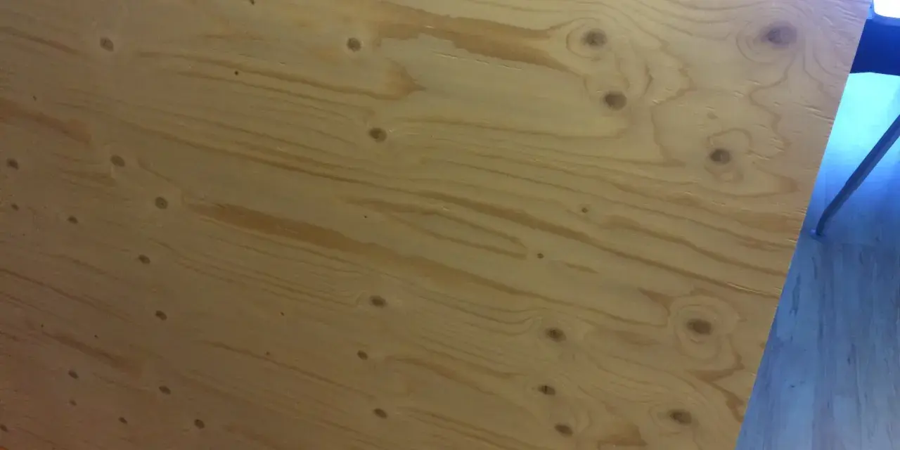 En stor skiva **betsa plywood** med tydliga ådringar och kvistar. Perfekt för ett rustikt projekt.