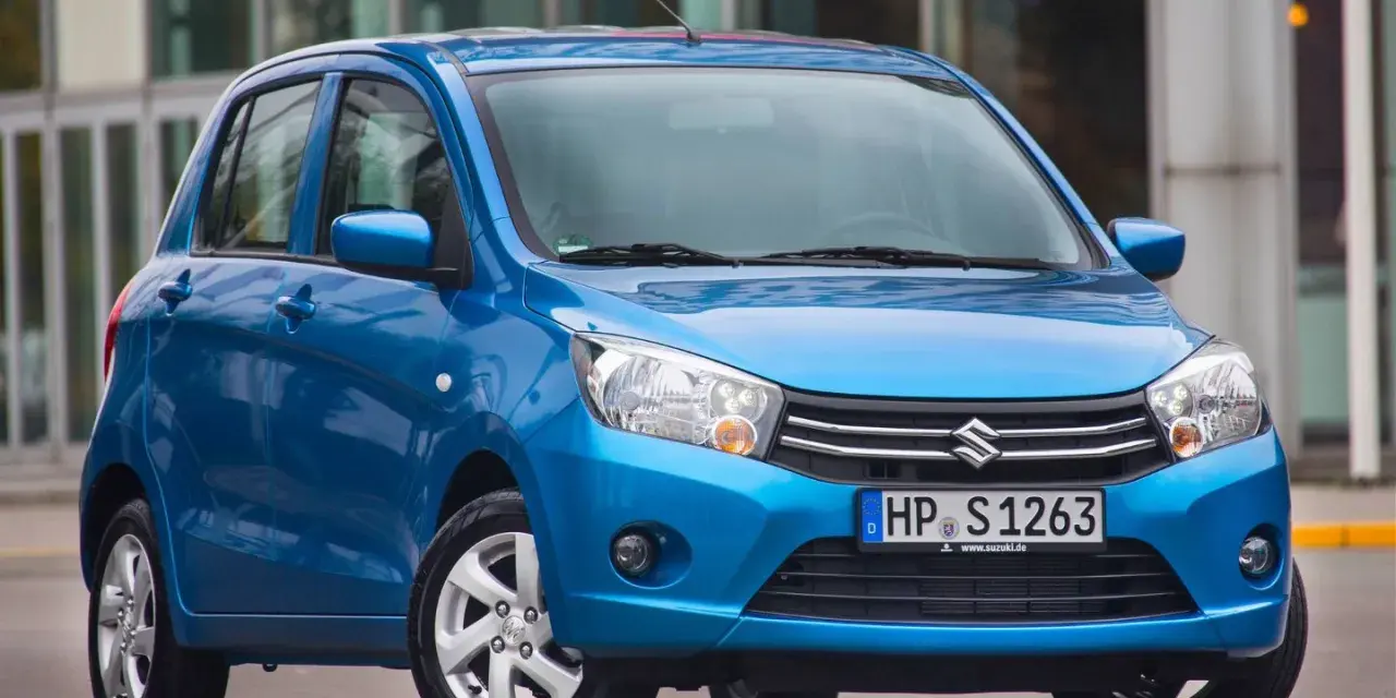 Niebieski Suzuki Celerio stoi przed nowoczesnym budynkiem.