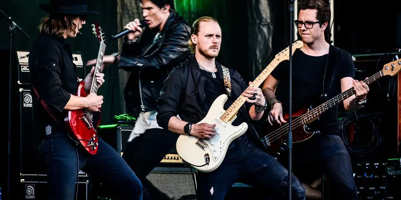 Zespół gra na scenie, wokalista śpiewa, gitarzyści i basista tworzą muzykę. Może to piosenka "Kocham Cię".