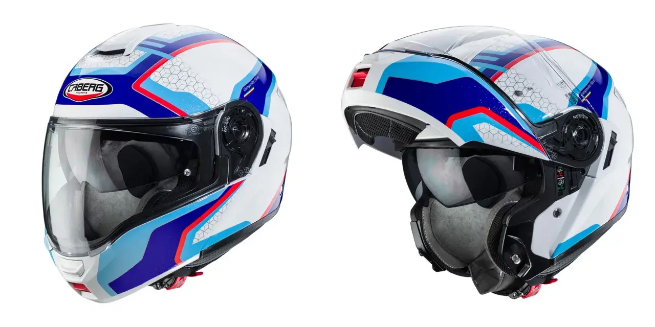 Due caschi integrali Caberg bianchi con grafiche blu, rosse e azzurre. Il casco integrale significa massima protezione.