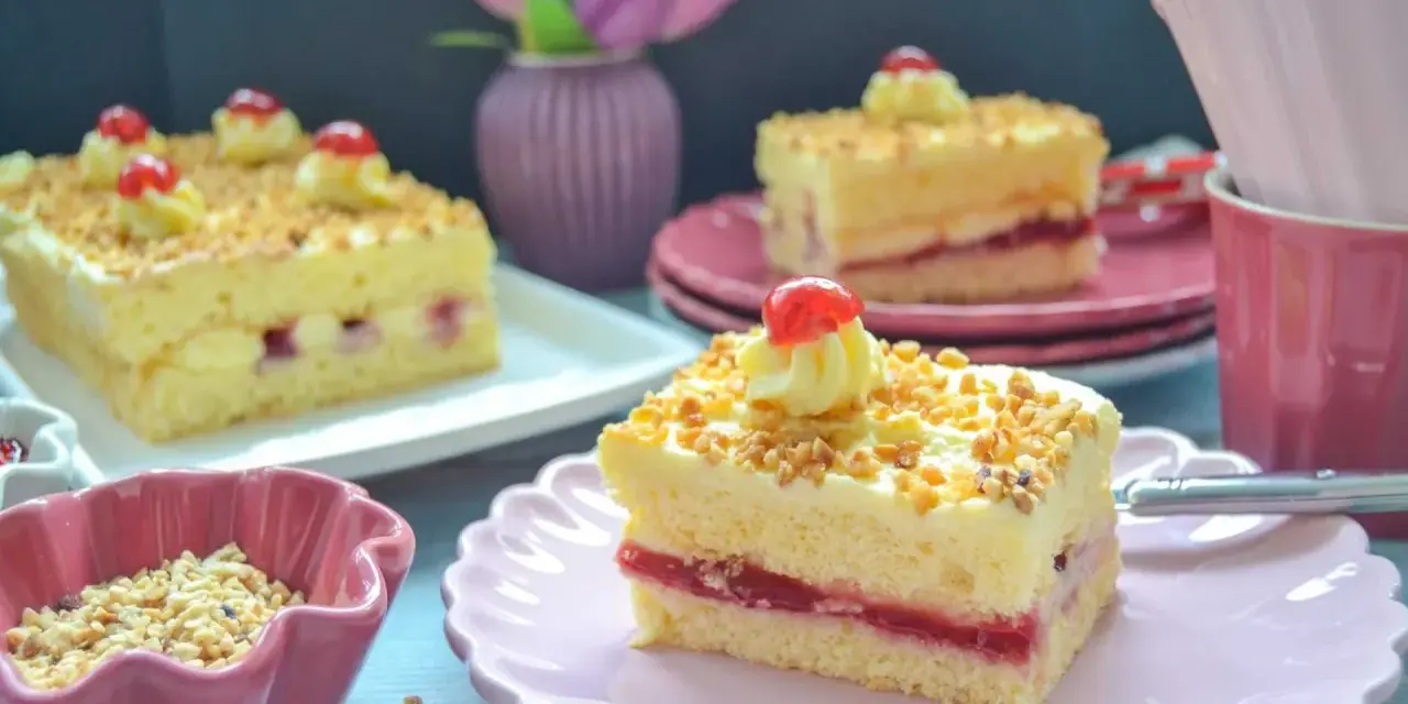 Stückchen eines Frankfurter Kranz Blechs mit Buttercreme, Kirschen und gehackten Nüssen.