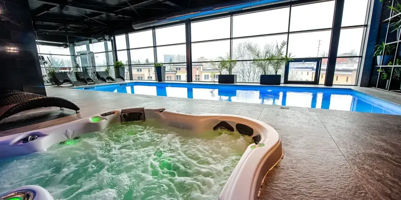 Relaks w hotelowym spa w Białymstoku: jacuzzi z bąbelkami i basen z widokiem na miasto.