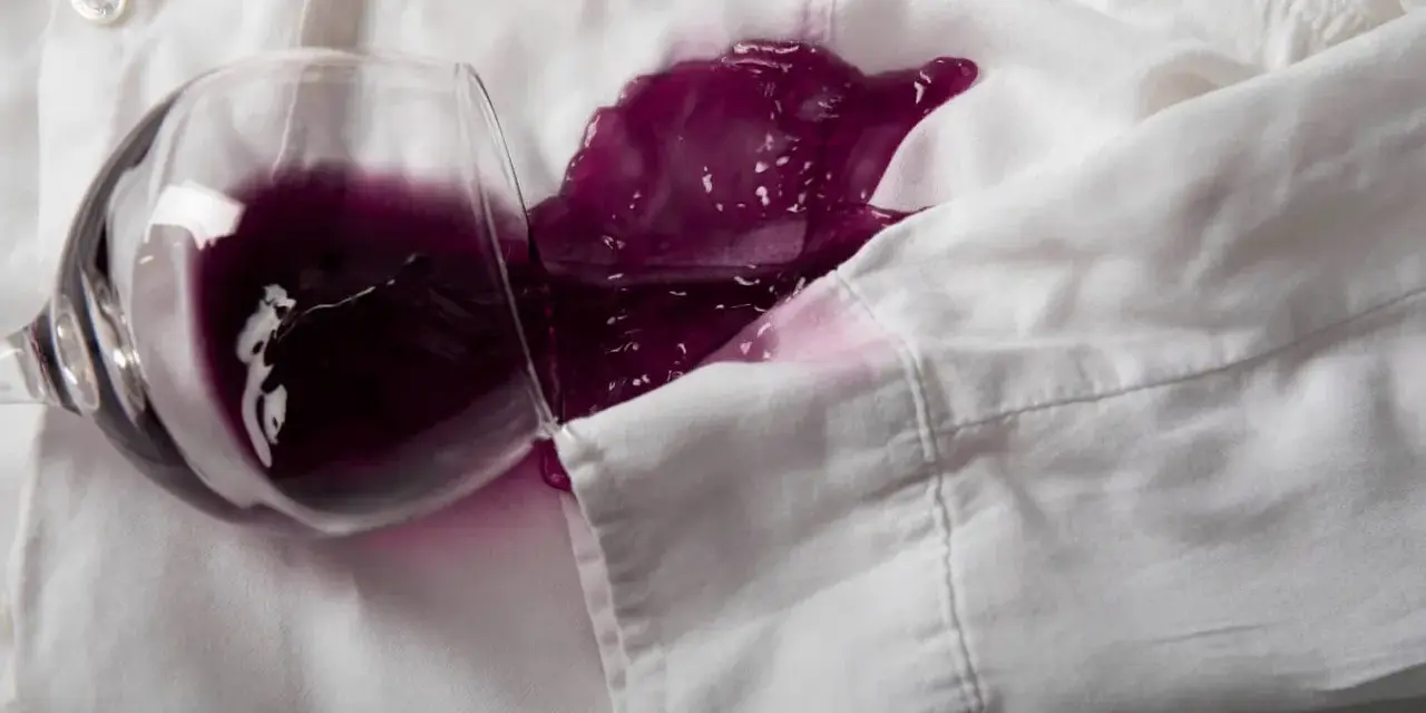 Un bicchiere rovesciato su una camicia bianca ha creato una macchia di vino rosso. Ecco come togliere macchie vino rosso secche.