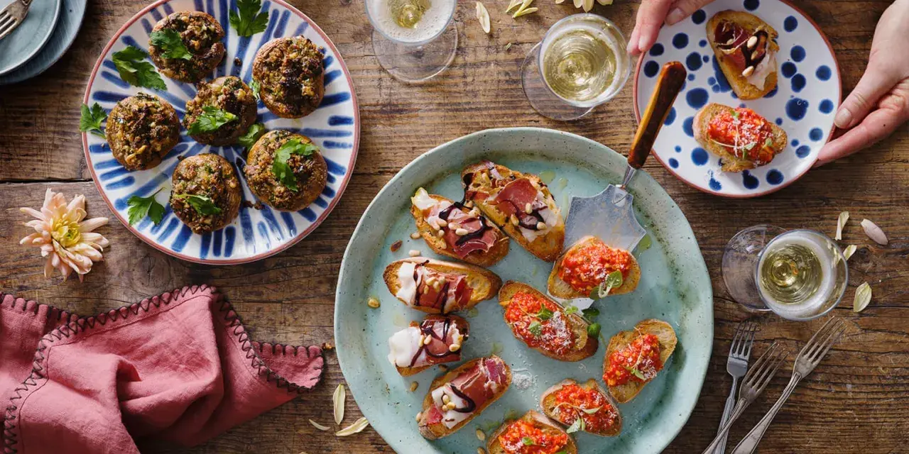 En härlig uppdukning med olika tapas recept. Små bruschettas med tomat, prosciutto och ost, samt fyllda champinjoner. Perfekt för en festlig stund!
