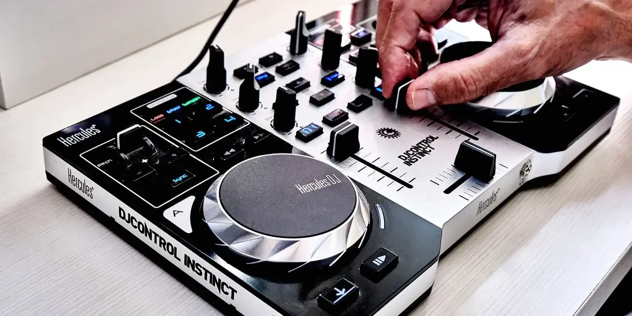 Dłoń DJ-a miksuje szybkie piosenki do tańca na kontrolerze Hercules DJControl Instinct.