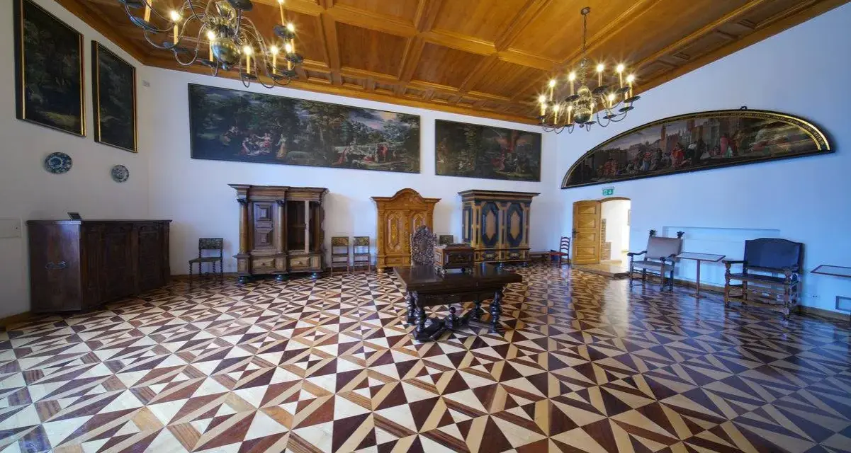 Wnętrze muzeum Gdańska - Ratusz Głównego Miasta. Bogato zdobiona sala z zabytkowymi meblami, obrazami i misterną parkietową posadzką.