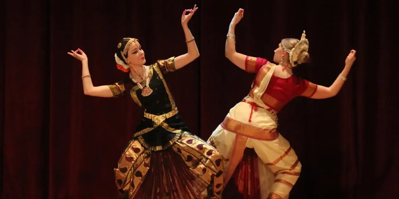 Anna Łopatowska i partnerka w tradycyjnych strojach tańczą taniec klasyczny Bharatanatyam.