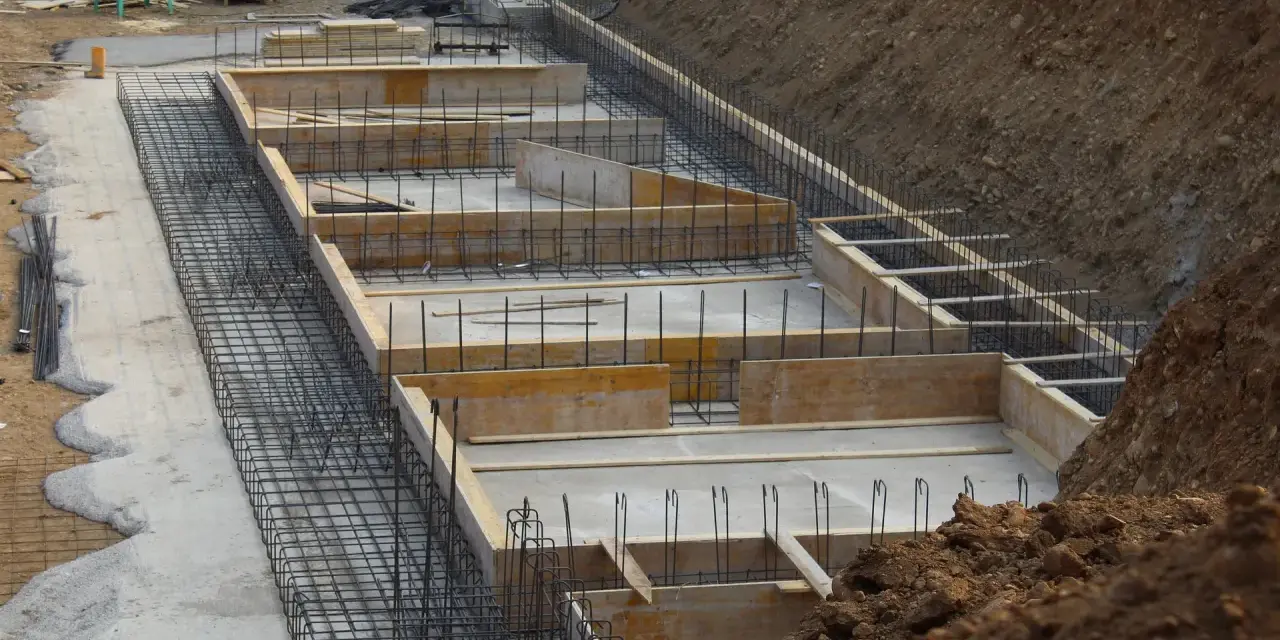 Szkielet zbrojeniowy i szalunki czekają na beton. Widać, ile bloczków na fundament potrzeba do budowy.