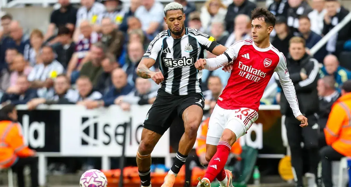Piłkarze Newcastle i Arsenal walczą o piłkę na boisku. Intensywna akcja podczas meczu.