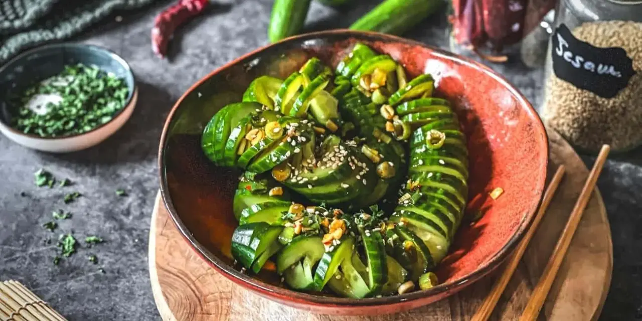 Ein erfrischender asiatischer Gurkensalat, garniert mit Sesam und Kräutern, bereit zum Genießen.