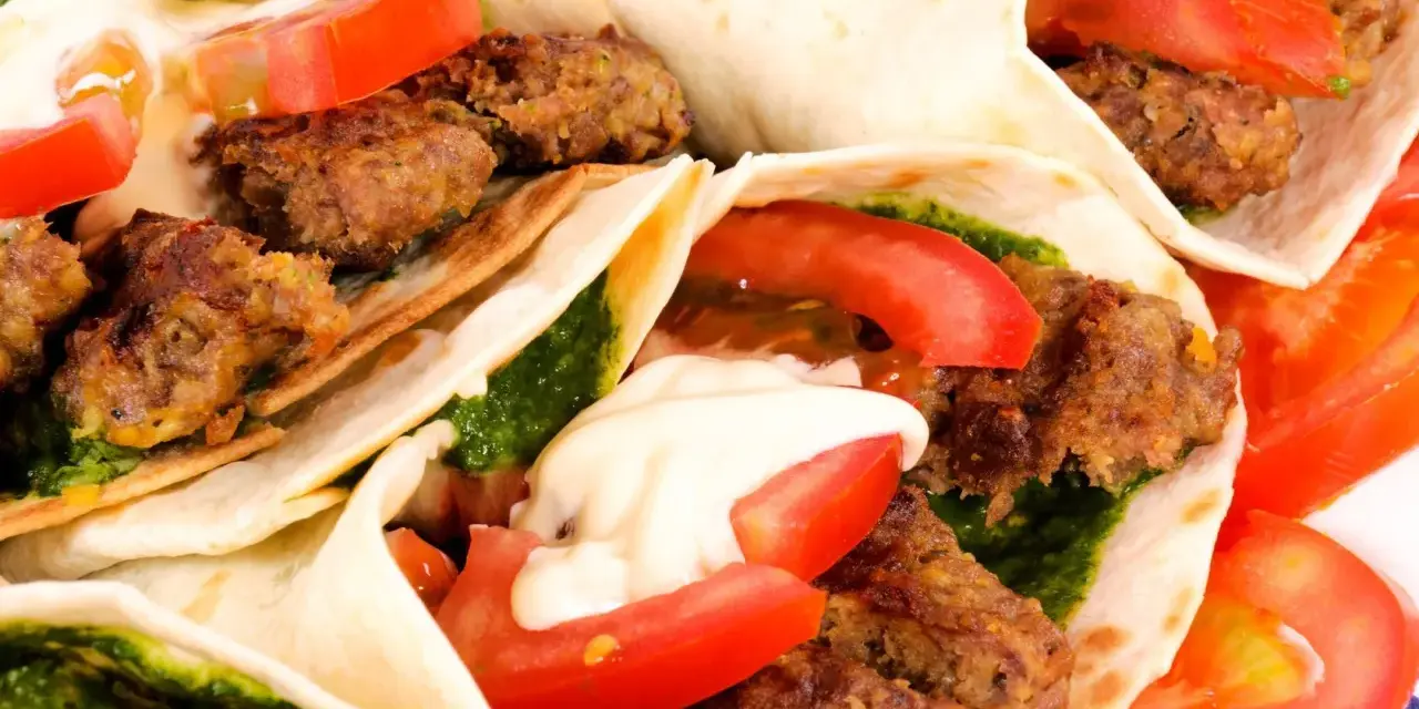 Zbliżenie na kilka kebabów w tortilli z mięsem, pomidorami, zielonym sosem i majonezem.