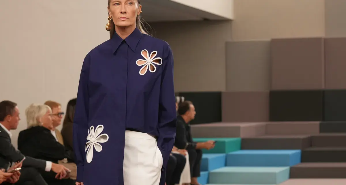 Modella con camicia blu Fendi e pantaloni bianchi, un'icona di stile che racconta la sua storia.