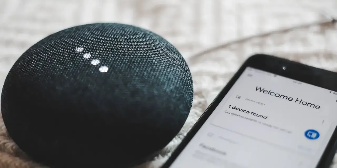 A smart speaker and phone display "Welcome Home" and "1 device found," showcasing modern iot design for a connected home.