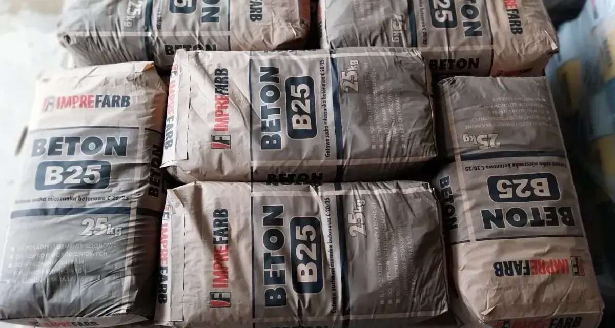 Sztaplowane worki z betonem B25, każdy po 25 kg. Wiedząc, ile waży kubik betonu, można oszacować potrzebną ilość materiału.