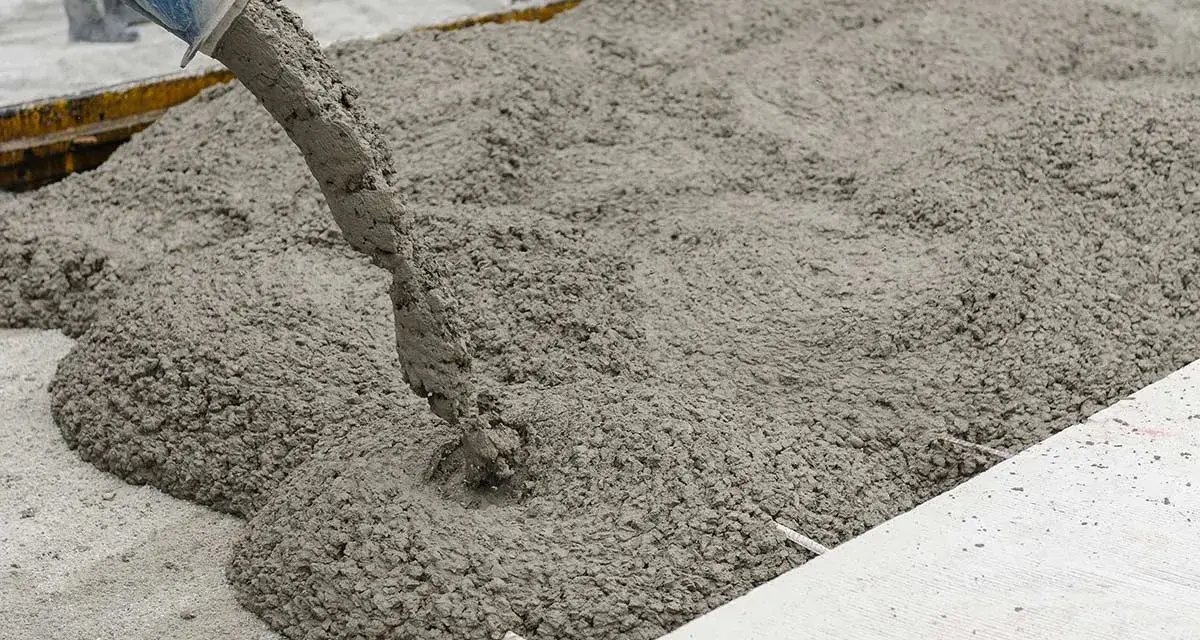 Calcestruzzo fresco versato da una pompa. La corretta tabella dosaggio calcestruzzo garantisce la qualità.