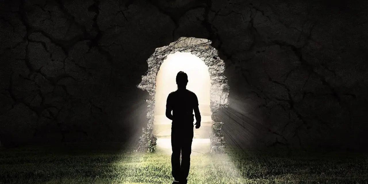 Ein Mann im Schatten tritt aus einer Höhle ins Licht. LK 21.