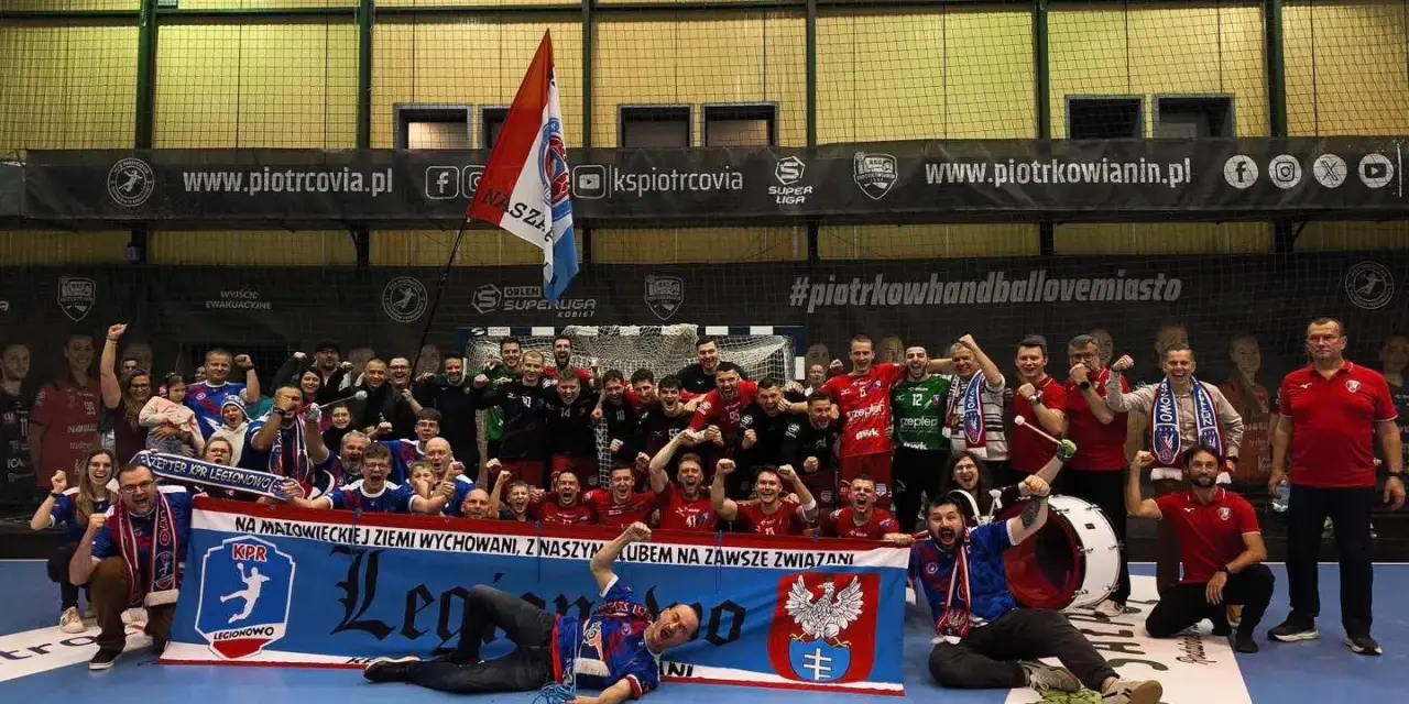 Drużyna KPR Legionowo świętuje zwycięstwo, trzymając transparent z herbem i hasłem.