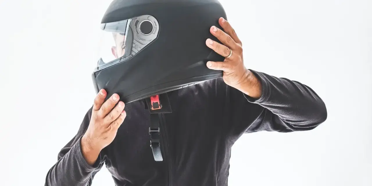 Persona indossa un casco integrale nero, pronto per un giro in moto.