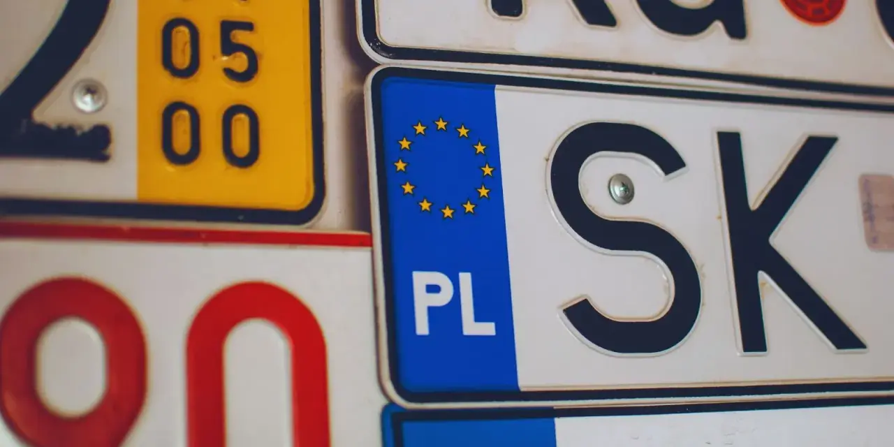 Kolekcja tablic rejestracyjnych, w tym polska z symbolem UE i oznaczeniem PL.