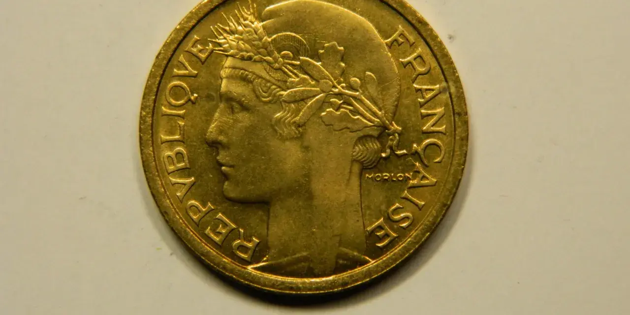 Une pièce de 1 franc 1948, en or, avec le profil d'une femme couronnée de blé. "République Française" est gravé sur le pourtour.