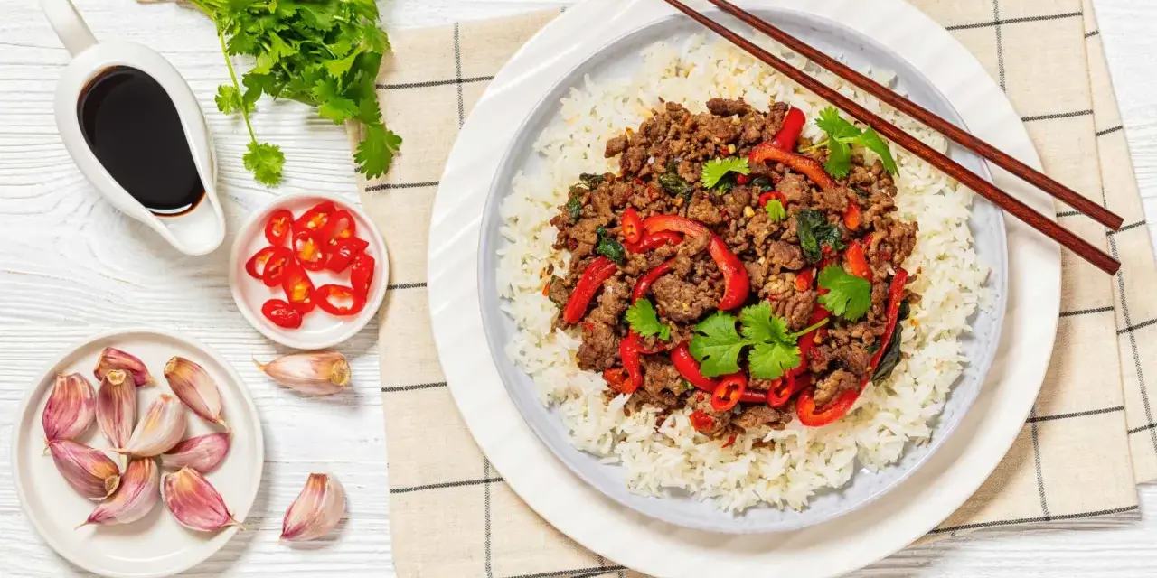 Delicioso arroz con carne picada, pimientos rojos y cilantro fresco. Acompañado de salsa de soja, chiles y ajos.