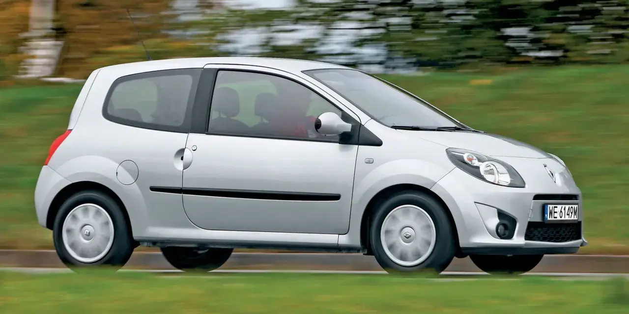 Srebrne Renault Twingo 2 w ruchu, z rozmytym tłem zieleni i drzew.