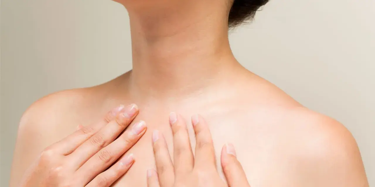 Mains caressant le cou et le décolleté, une invitation à muscler son cou pour une posture élégante.